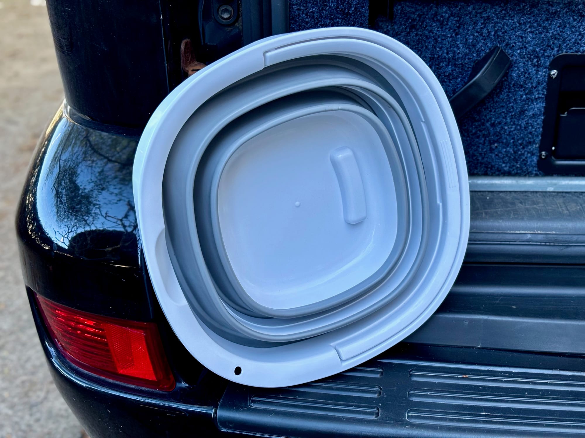 The folded Seymour’s bucket leaning against the back of the Prado by the tail light