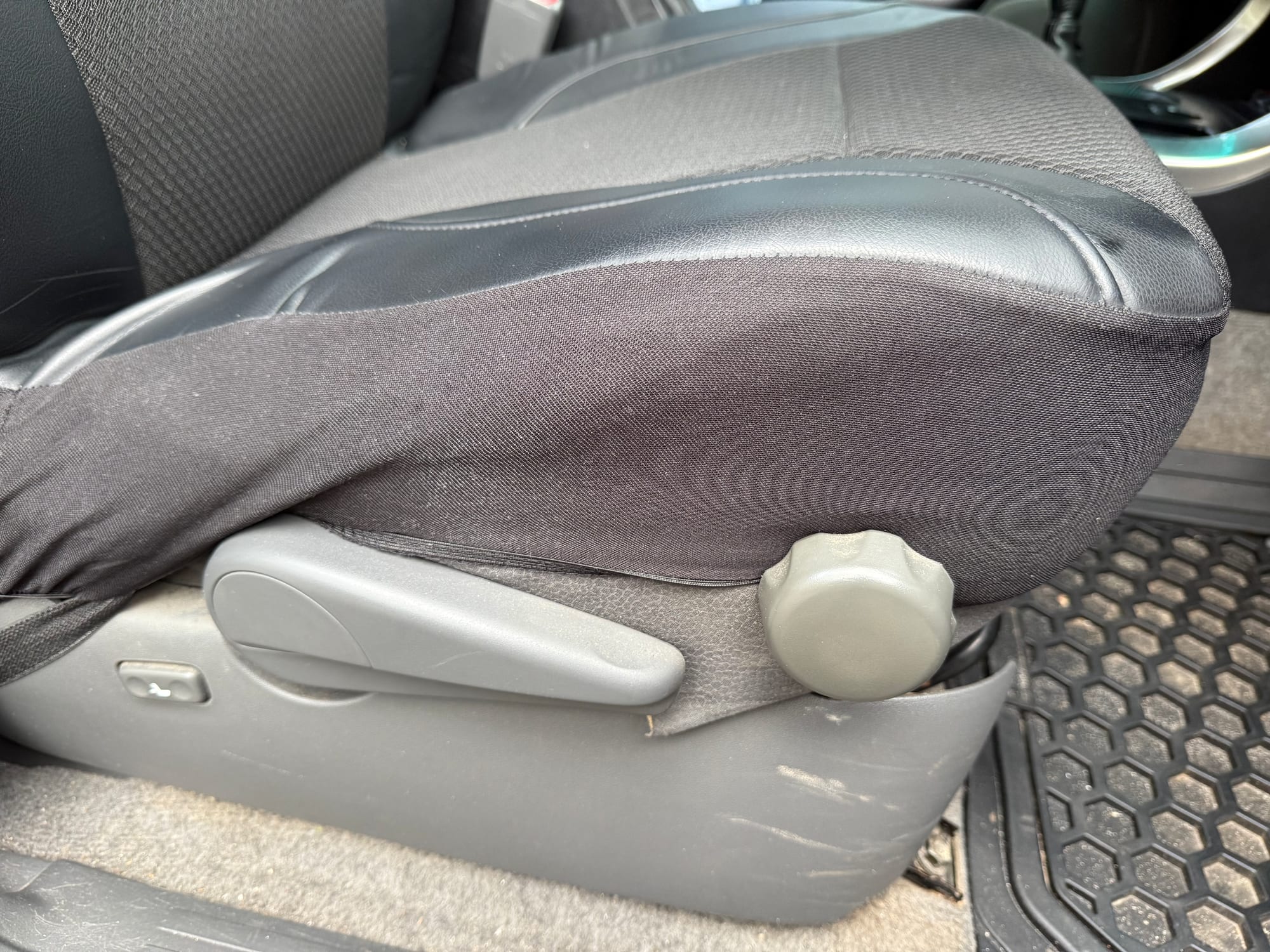 The bottom of the Skechers seat cover stretched around the side of the seat base, with the seat adjusters free