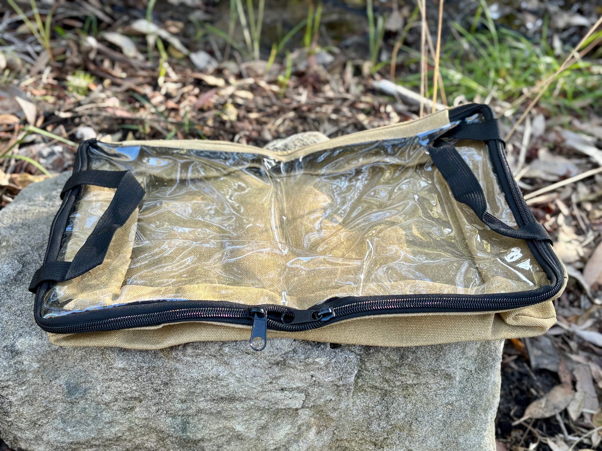 The clear lid of the Slimbridge canvas bag, zipped shut, with its handles folded out