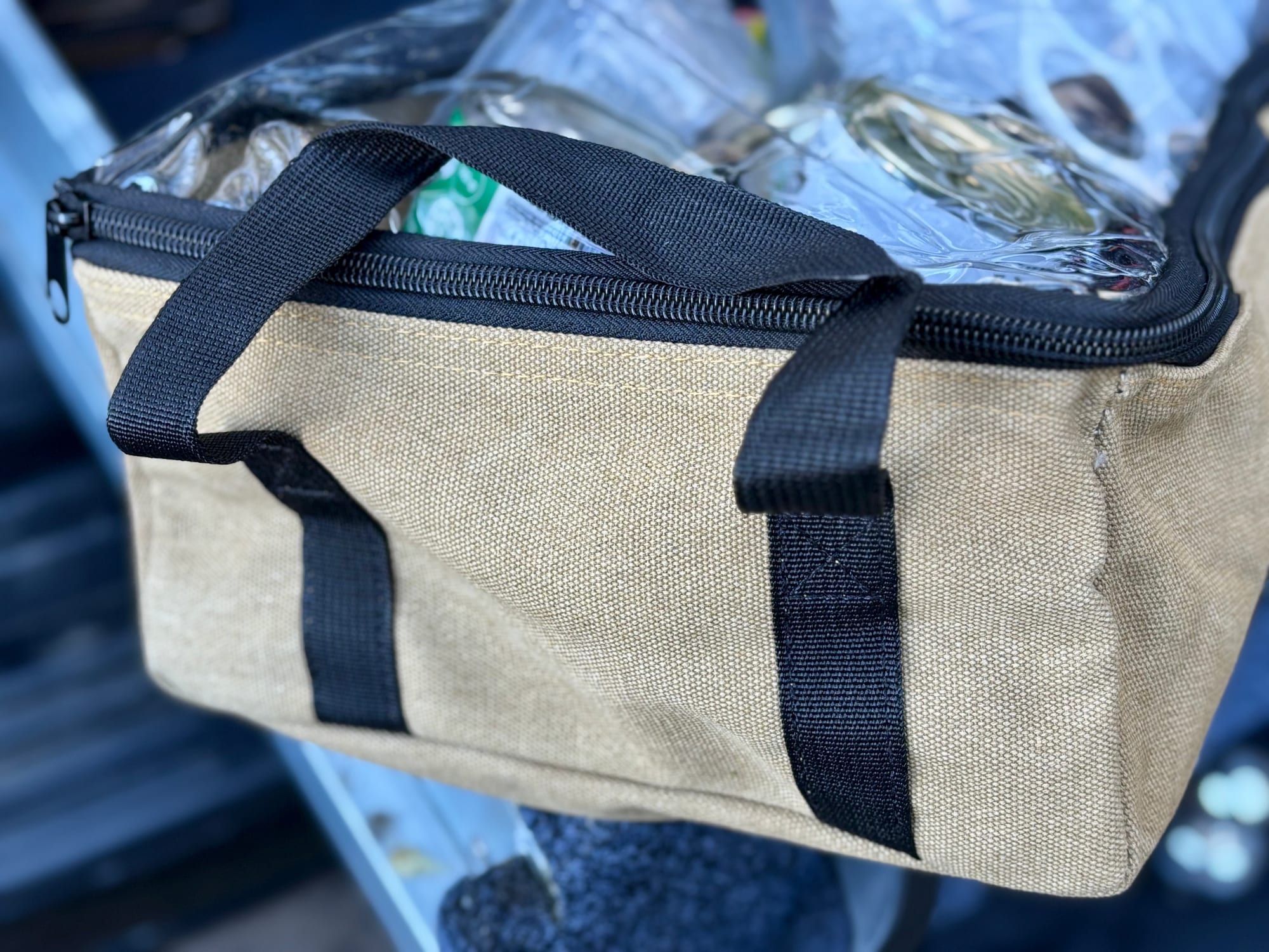 A packed Slimbridge canvas bag with its carry handles up, in the back of the 4WD