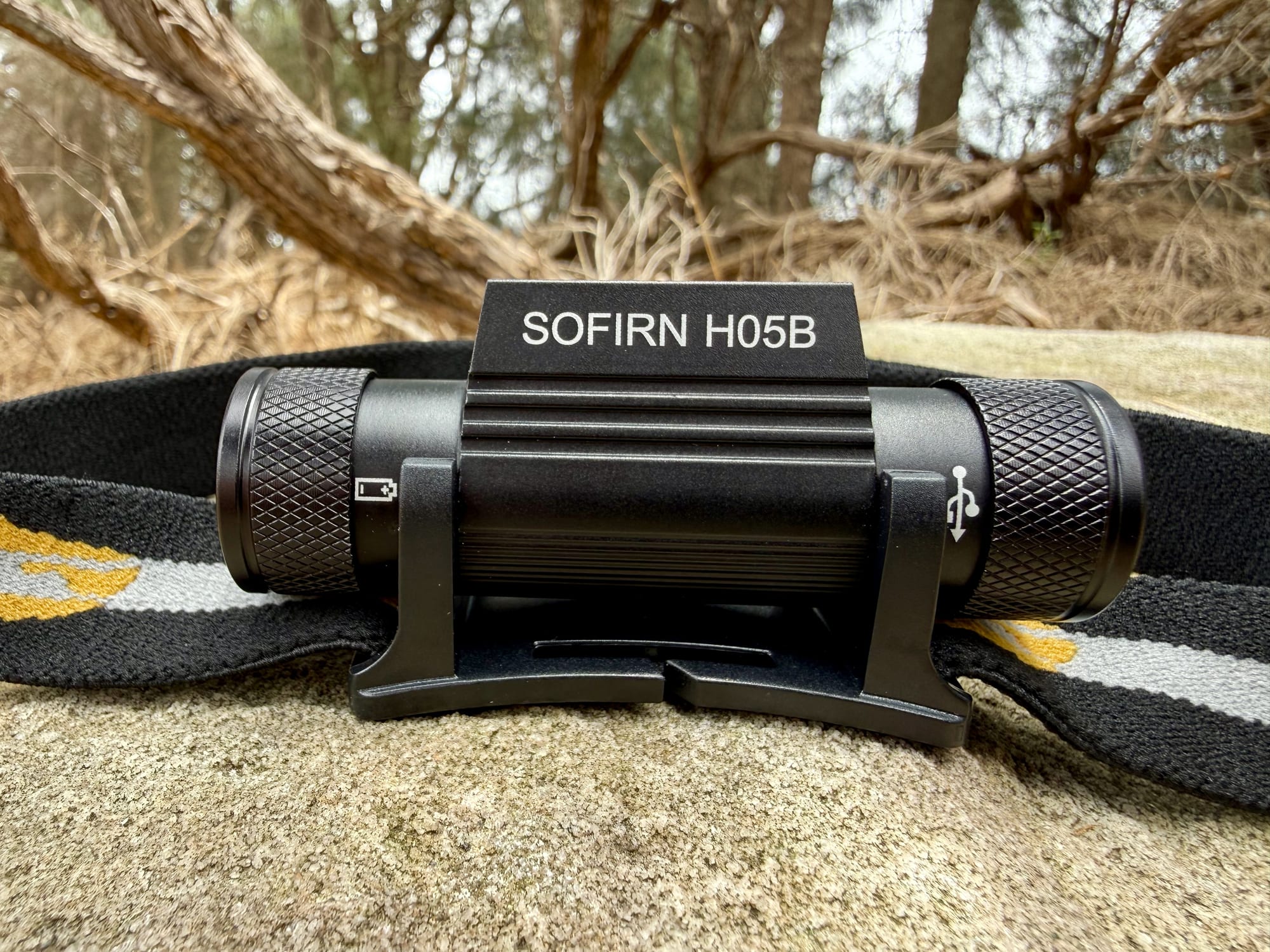 The back of the Sofirn H05B with the battery and USB symbols