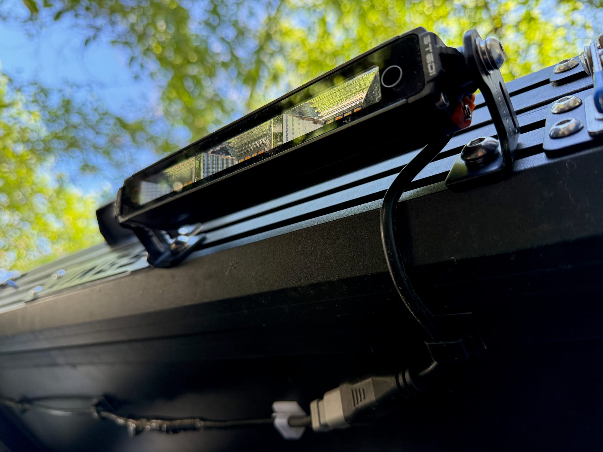The light’s cable running down from the bracket to the Deutsch connector under the rooftop tent