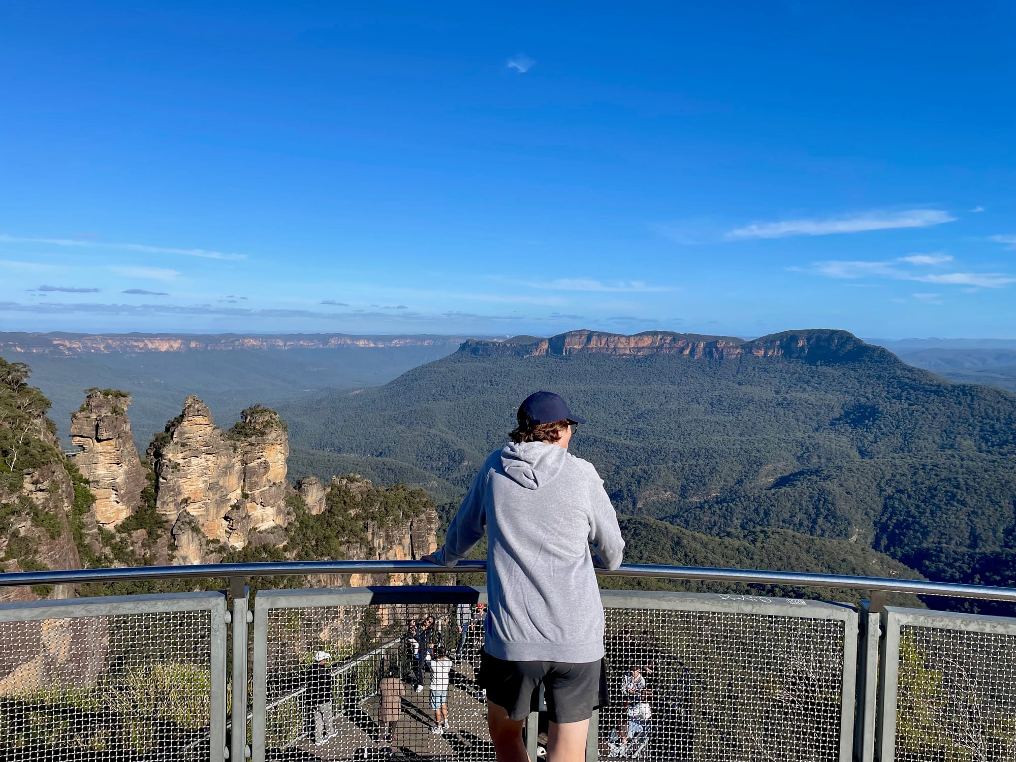 Looking out over the Three Sisters and the valley from the railing of an upper viewing platform at Echo Point