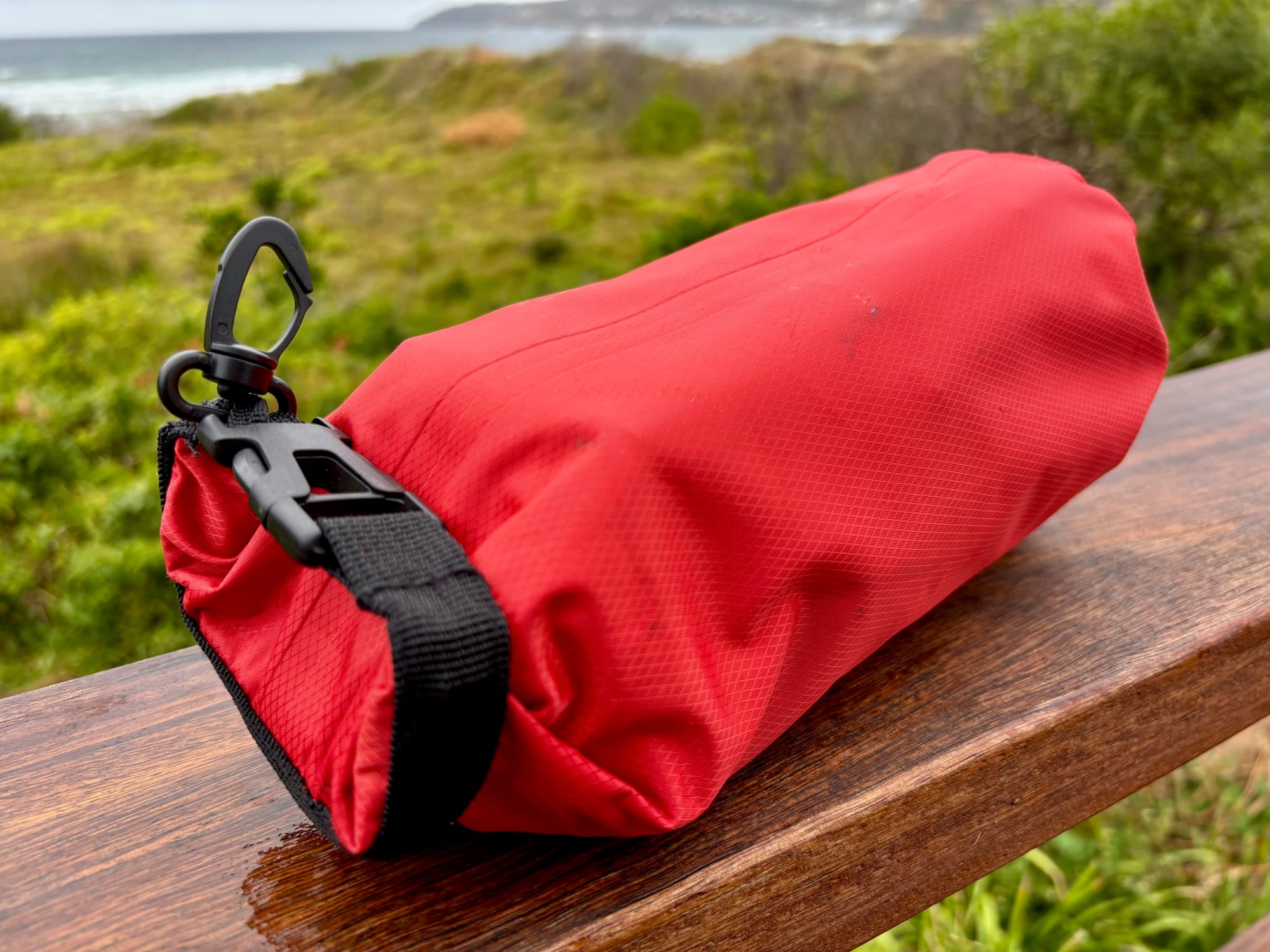 The roll-top closure and carabiner clip of the red first aid dry bag