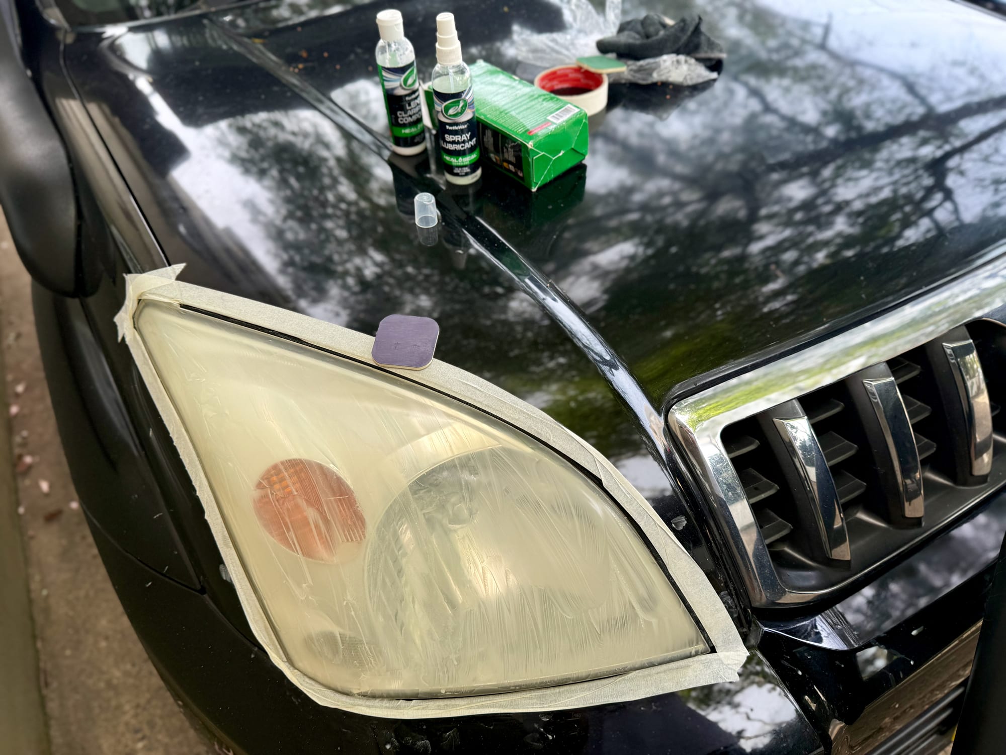 The masked headlight with an even milky haze over the lens after sanding