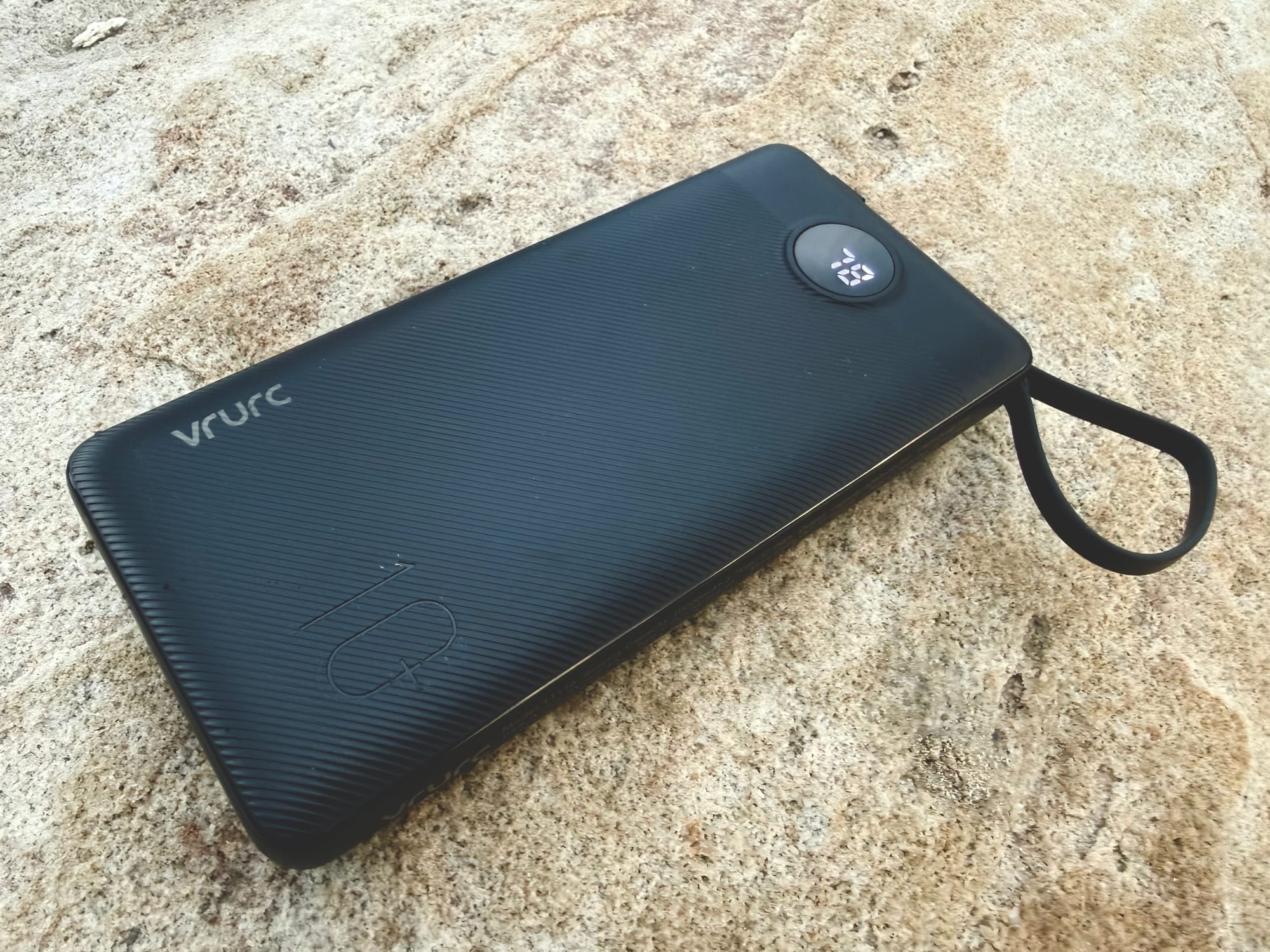 The front of the VRURC 10,000mAh power bank with its round percentage display and carry loop