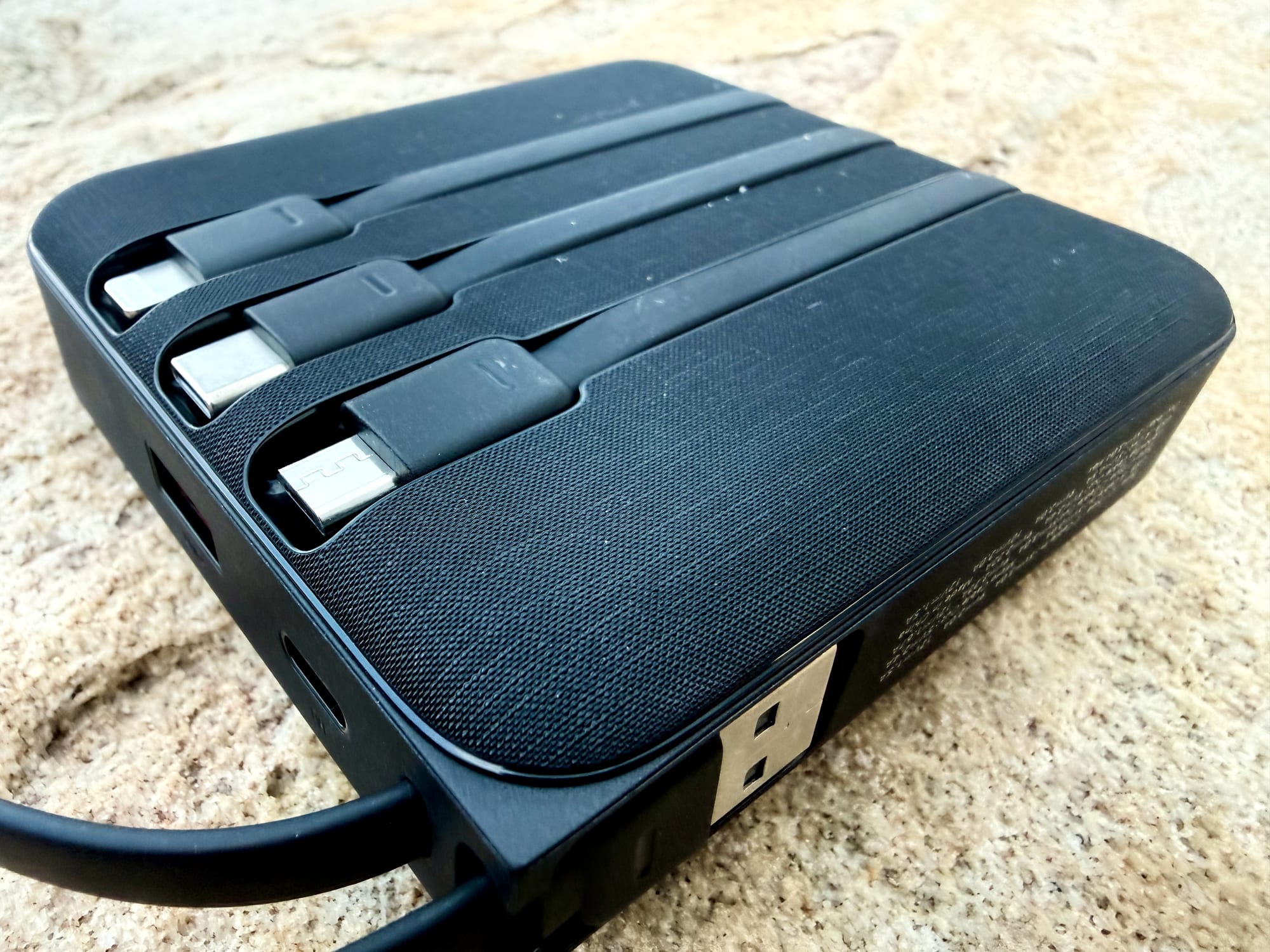 The Lightning, USB-C and Micro-USB cables clipped into the back of the VRURC power bank