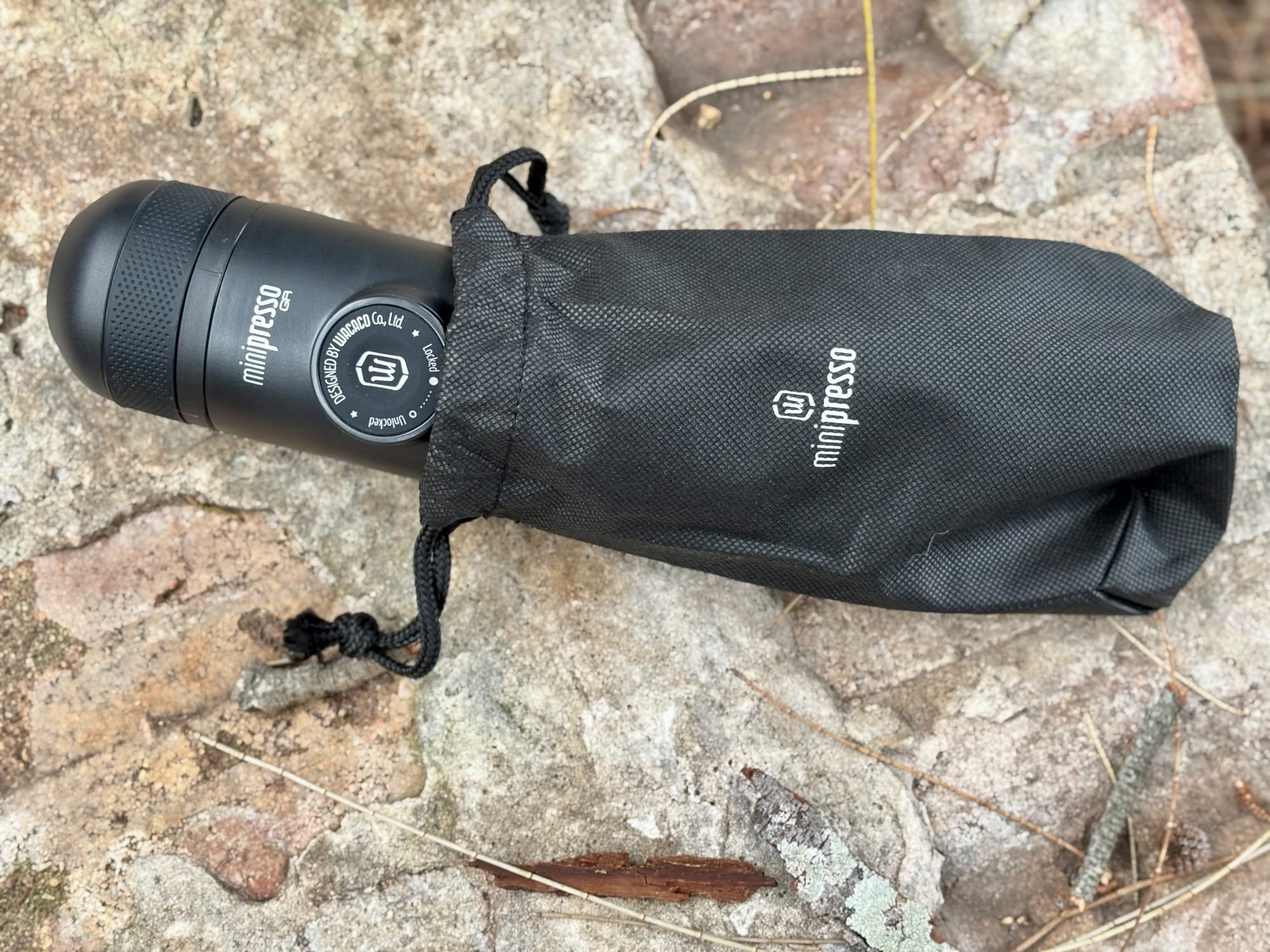 The Wacaco Minipresso GR next to its drawstring storage pouch
