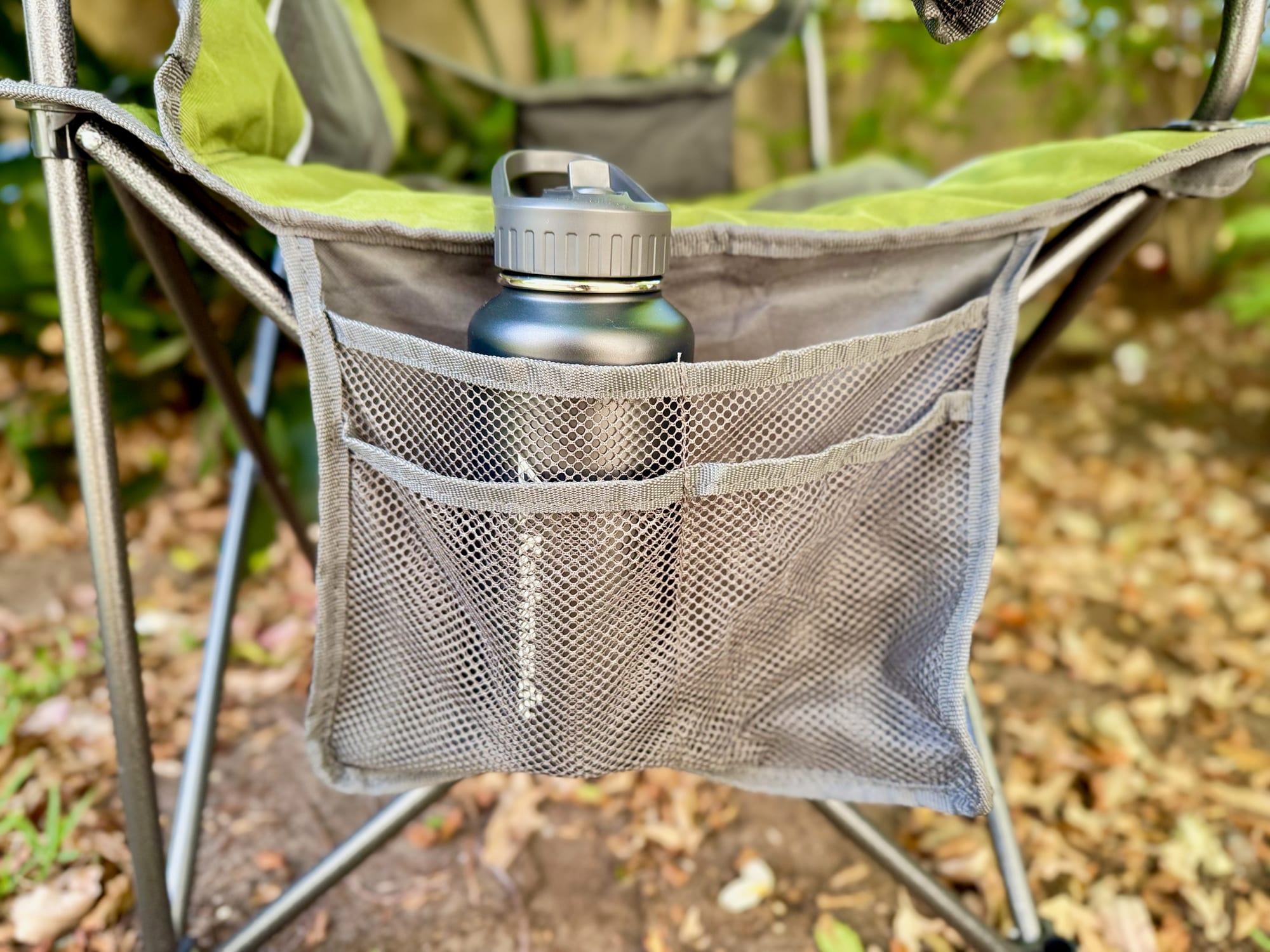 The mesh side pocket of the Wanderer Premium chair holding a drink bottle