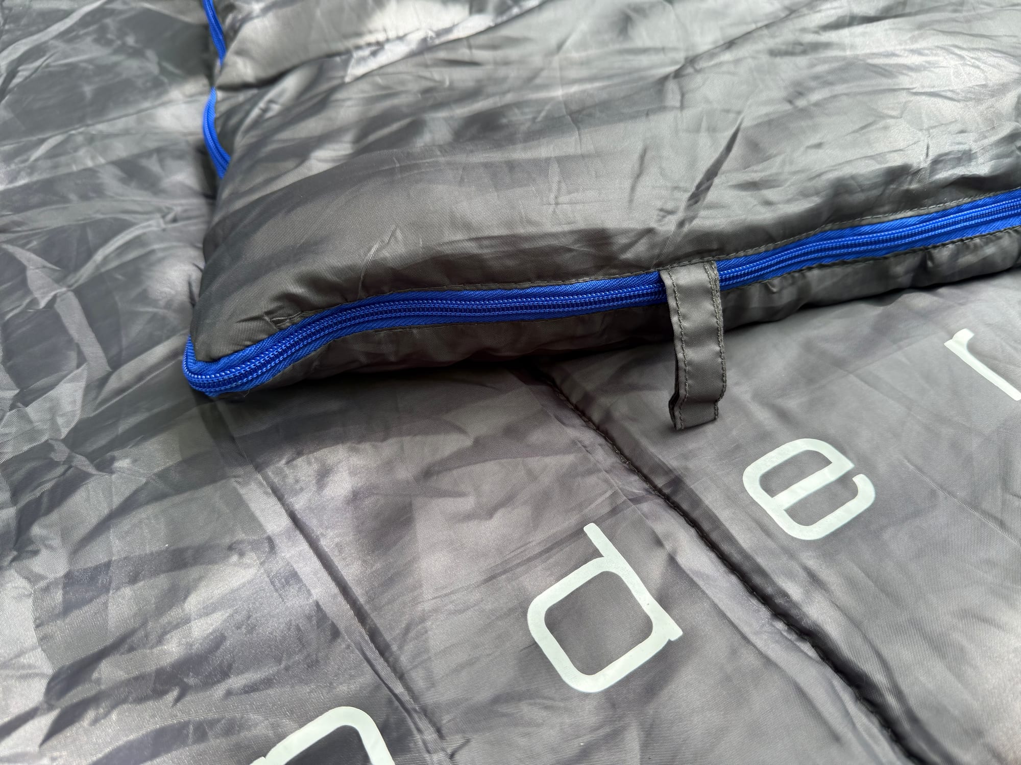 One of the two fabric hanging loops at the foot of the Wanderer sleeping bag, next to the blue zip