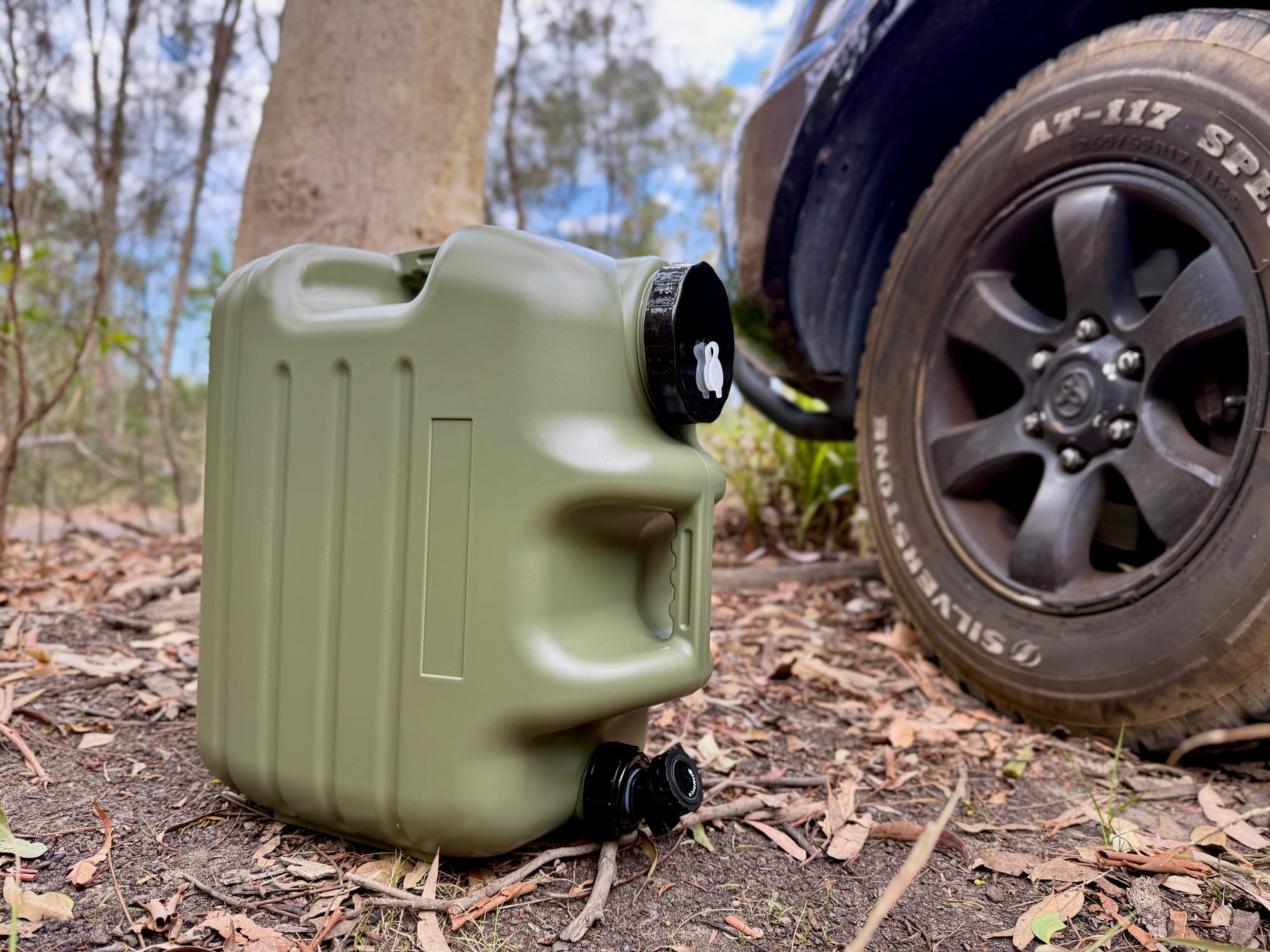 The Weisshorn 25L container from the side, with the tap at the bottom, next to a 4WD wheel