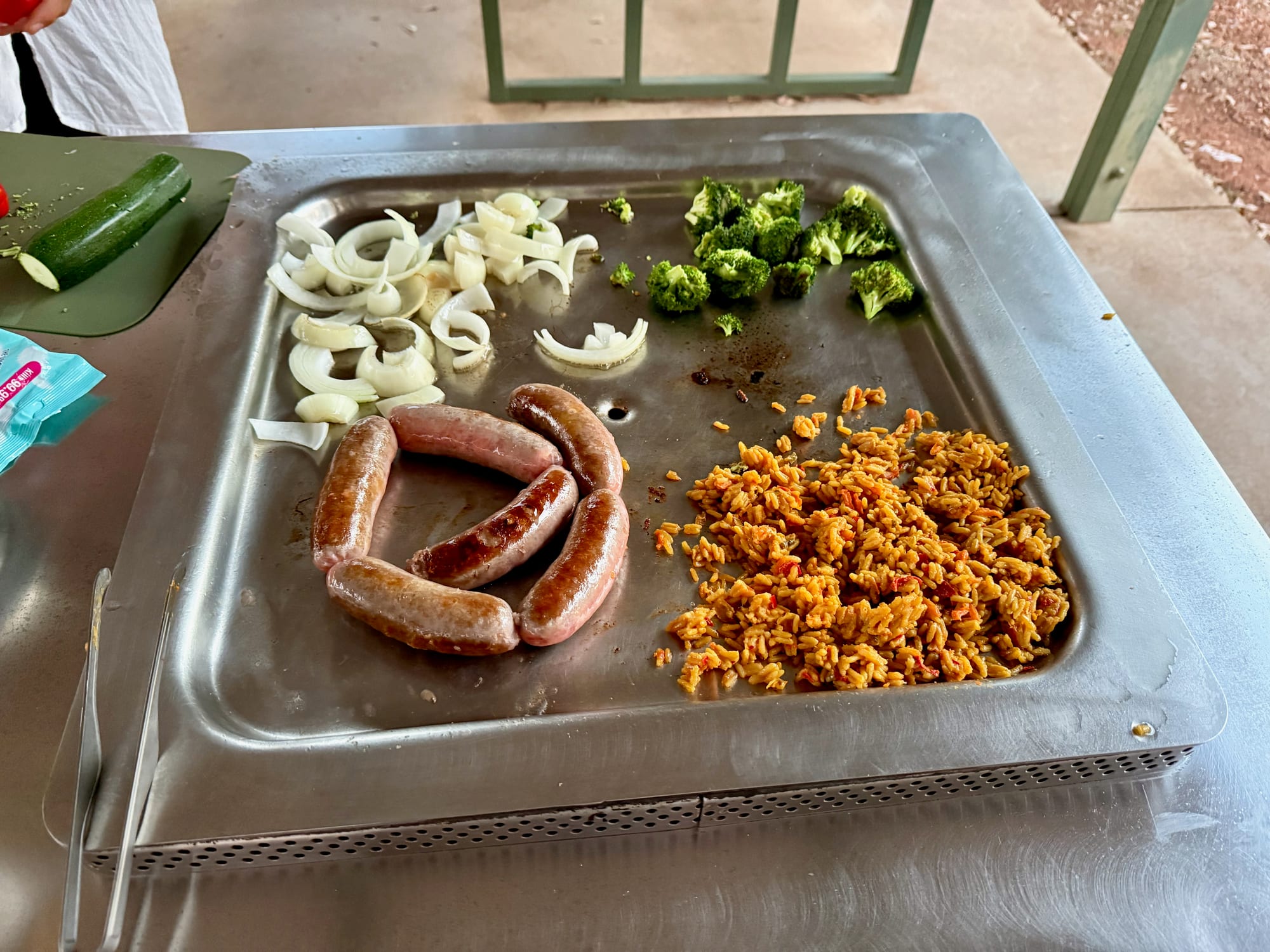 Sausages, onion and broccoli cooking on the free barbecue at Woolshed Flat Campground