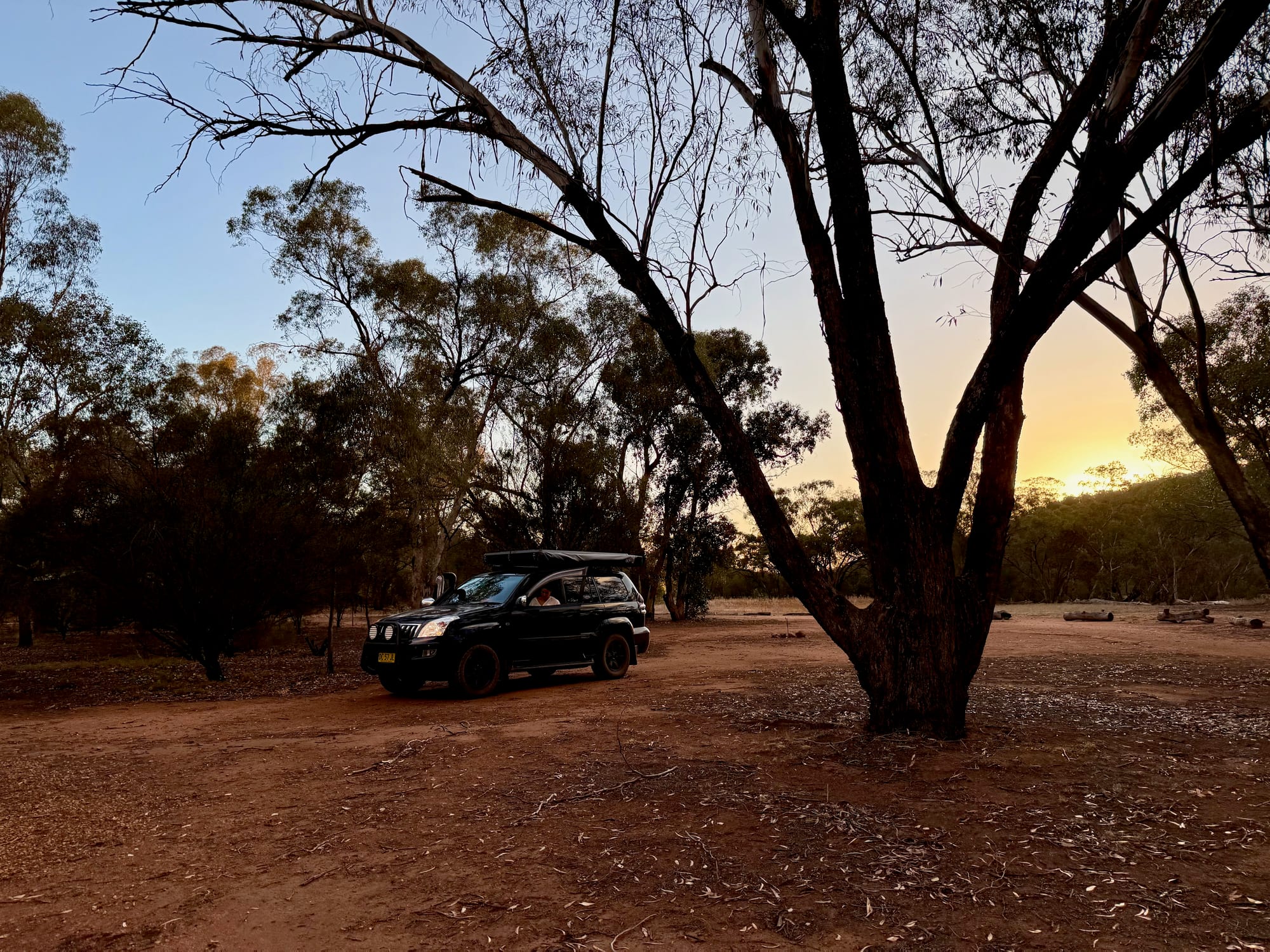 Our 4WD on its site at Woolshed Flat Campground as the sun goes down