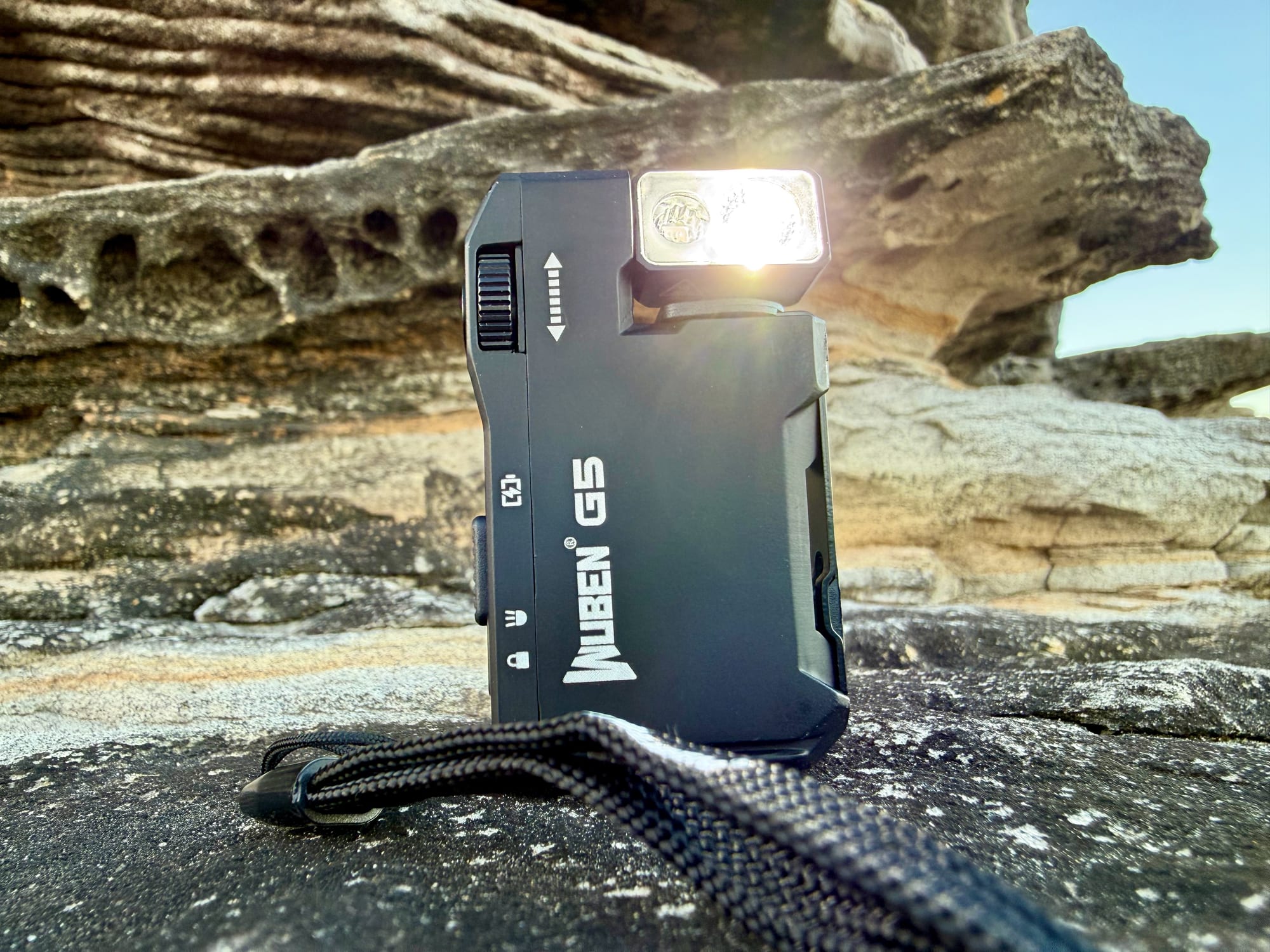 The Wuben G5 standing on a rock with its white light on