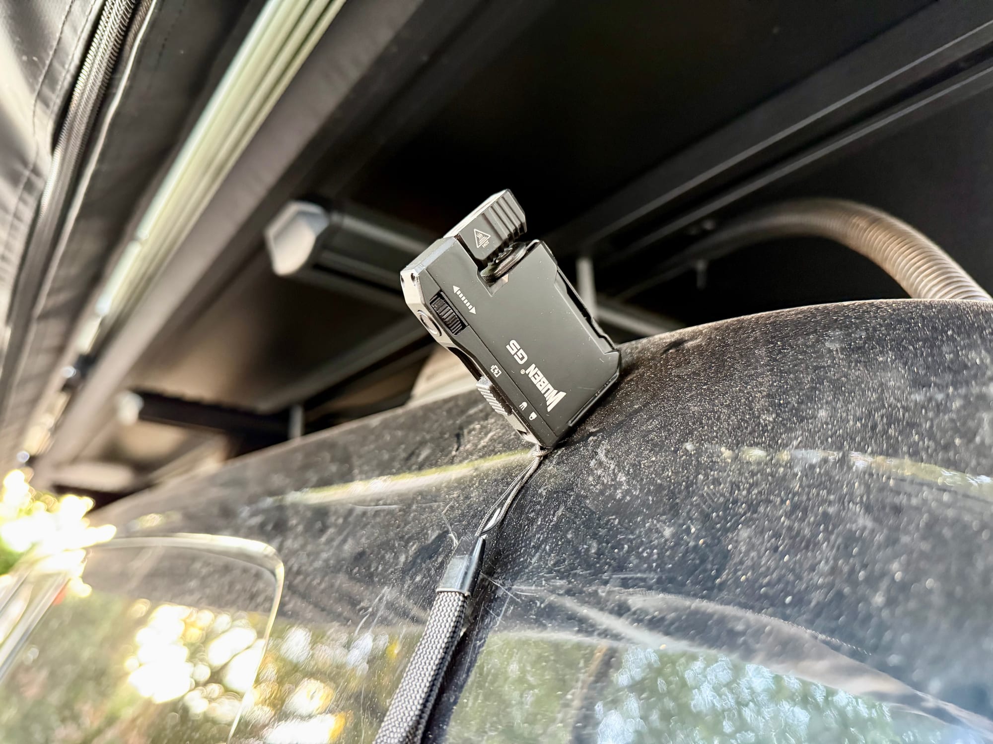 The Wuben G5 held by its magnet on the 4WD, next to the rooftop tent