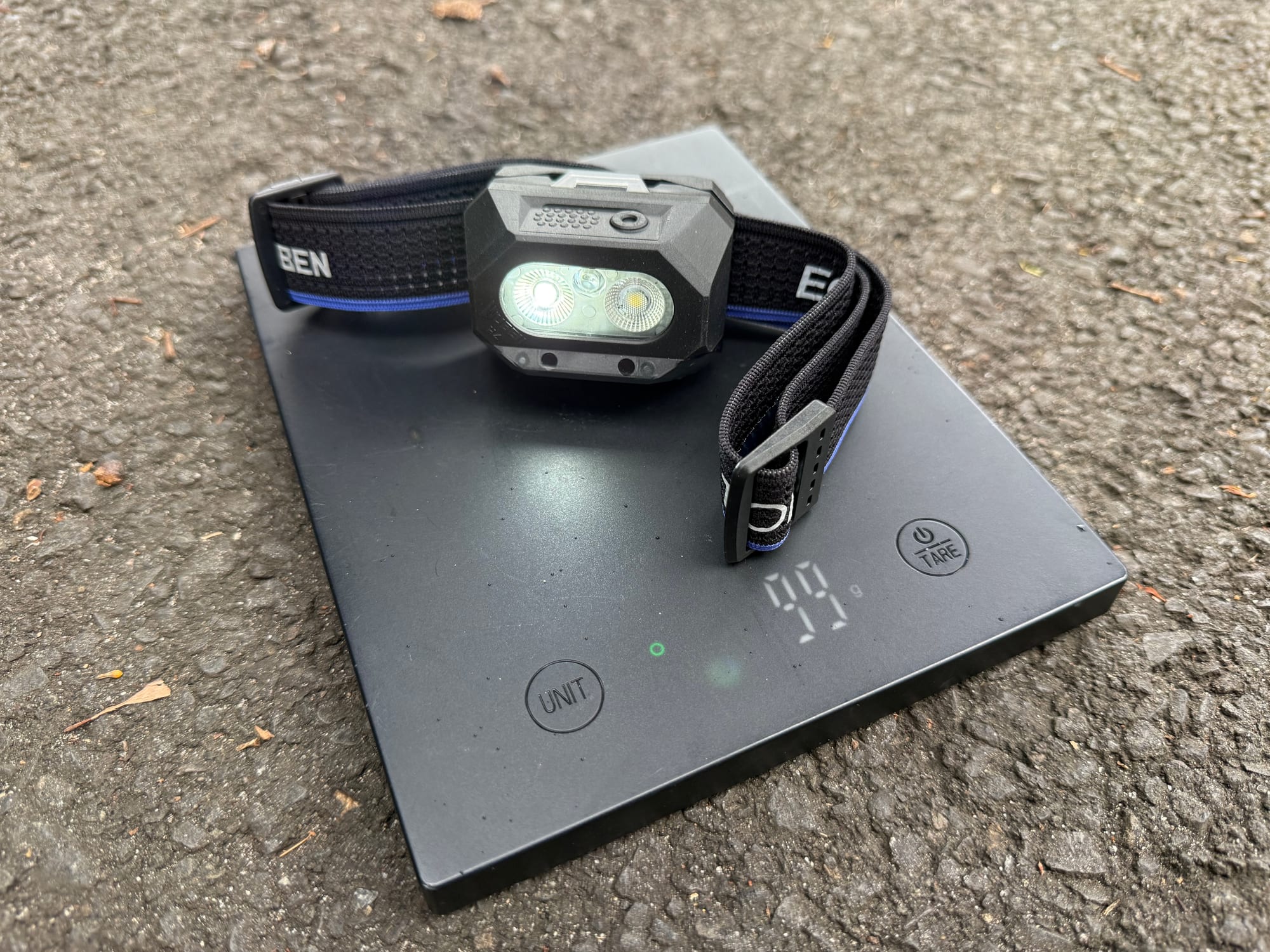 The Wuben H4 on a scale showing 99 g