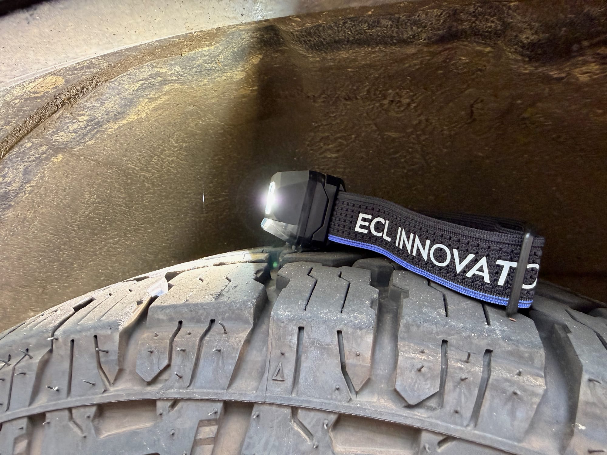 The Wuben H4 switched on, lying on the tread of a 4WD tyre