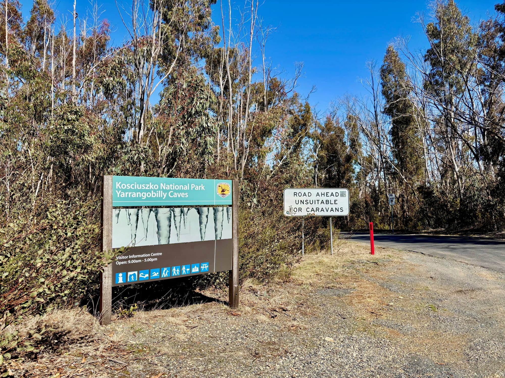 The Kosciuszko National Park sign at the Yarrangobilly Caves turn-off, next to a sign that the road is unsuitable for caravans