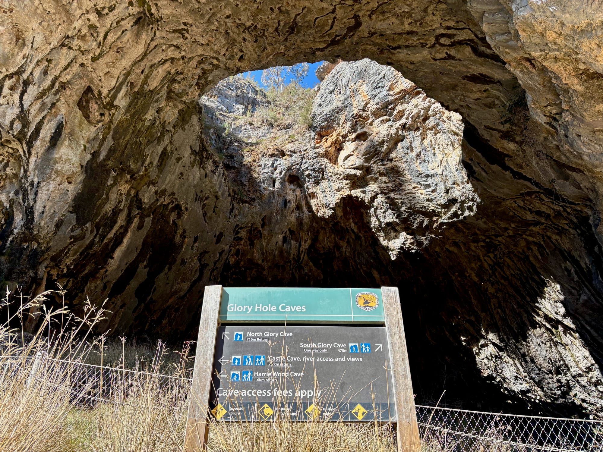The Glory Hole Caves sign under the arch, with directions to North Glory Cave, South Glory Cave, Castle Cave and Harrie Wood Cave