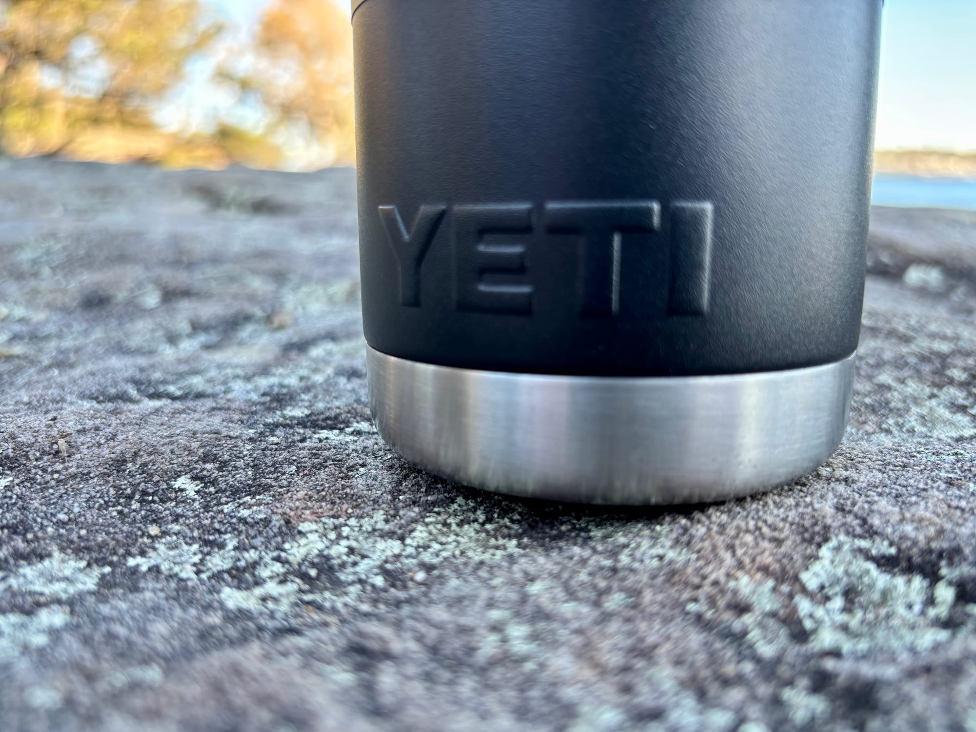 The embossed YETI logo and the bare steel band at the base of the bottle