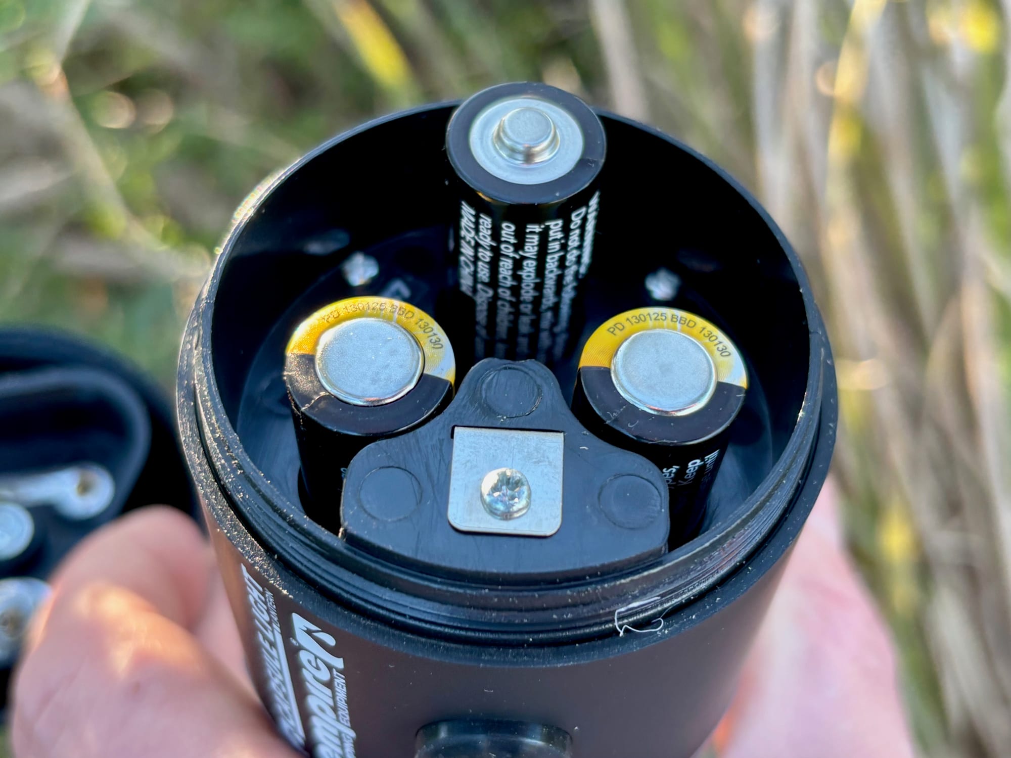 The open base of the Zempire Capsule Light with three AA batteries inside