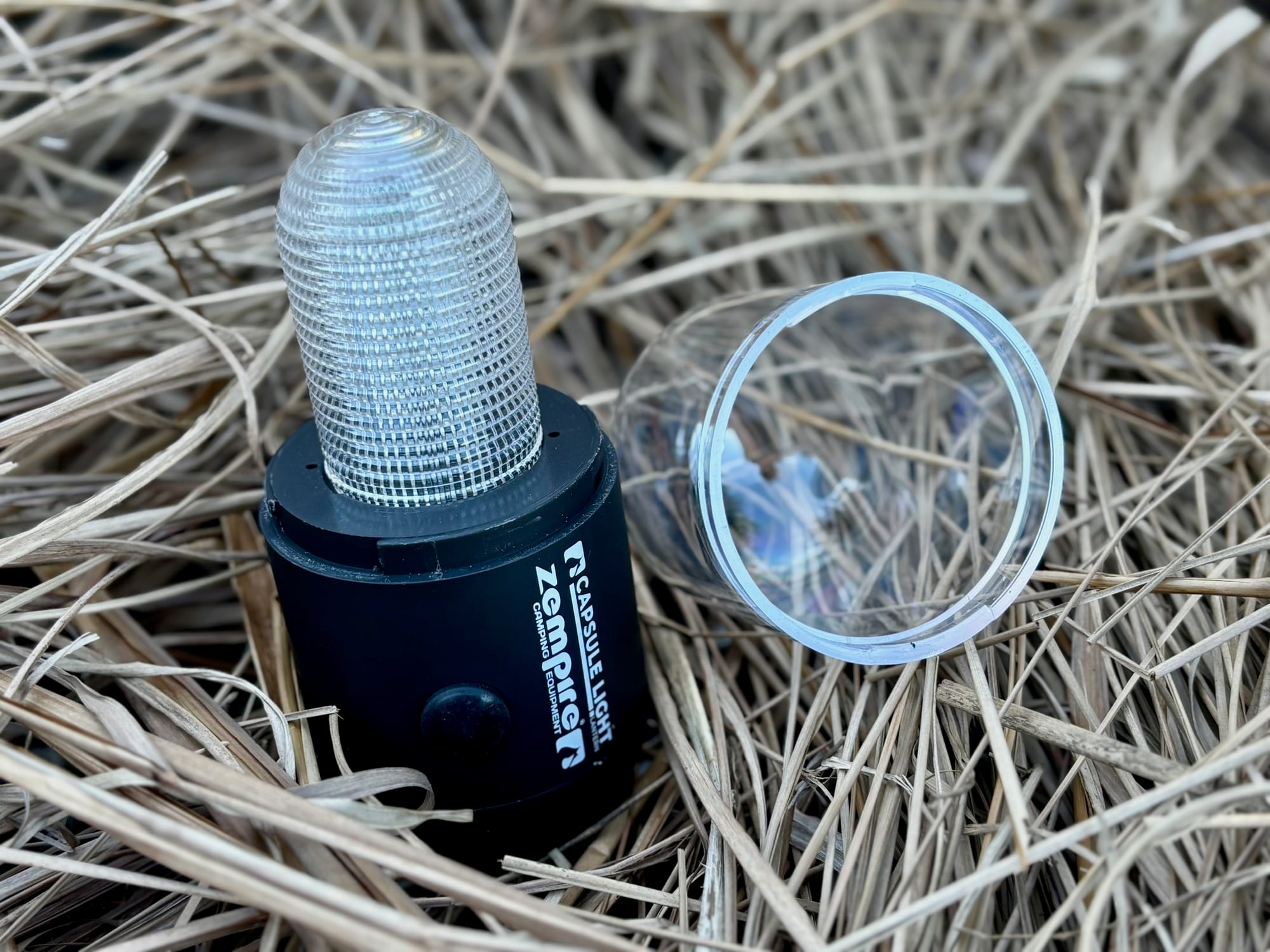 The Zempire Capsule Light with its clear cover taken off, lying next to it