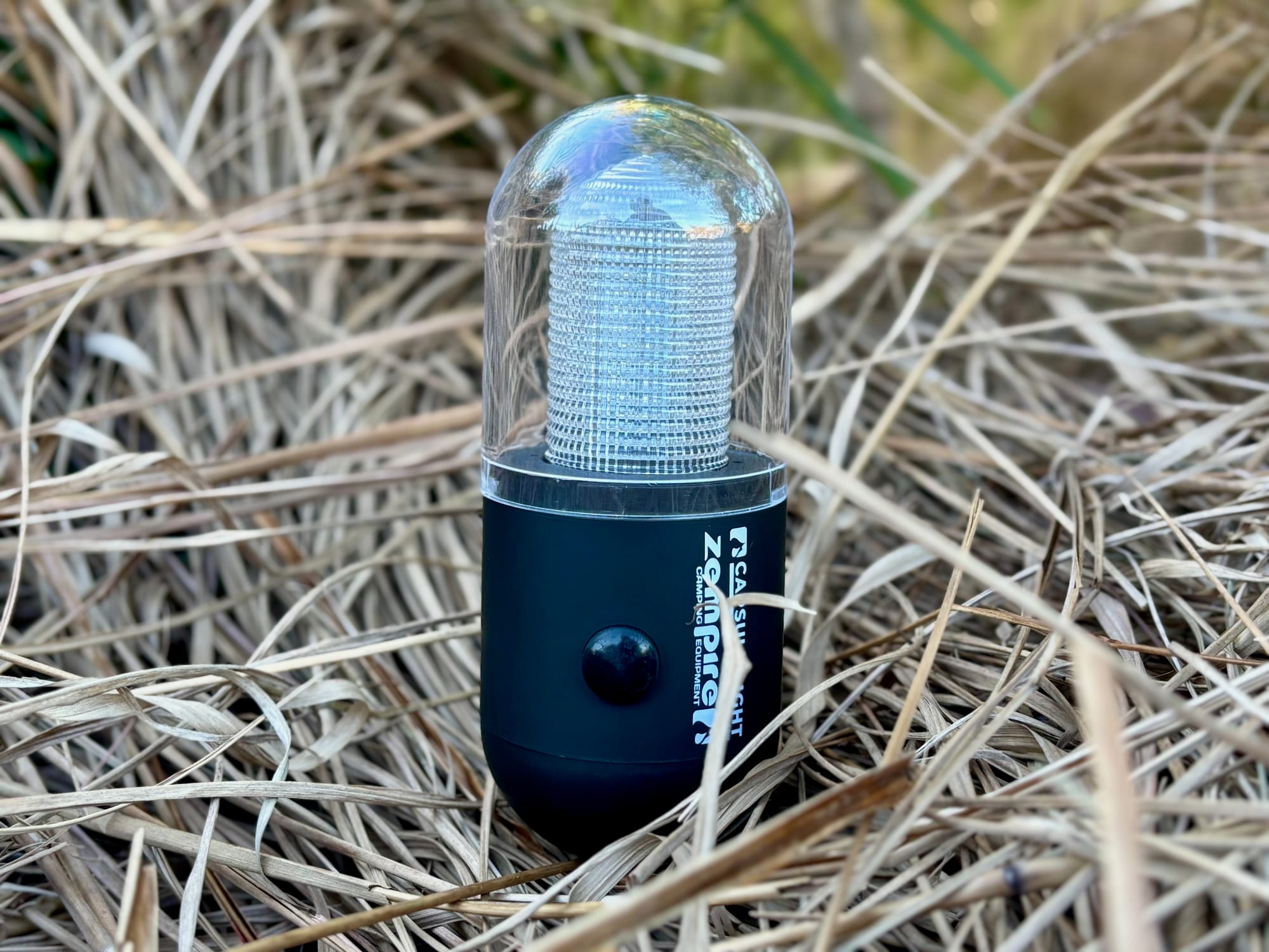 The Zempire Capsule Light standing upright in dry grass