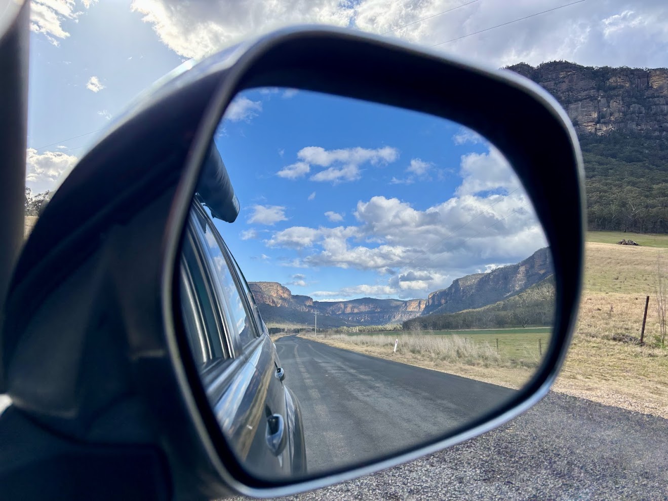 The valley and cliffs in the wing mirror on Glen Davis Road