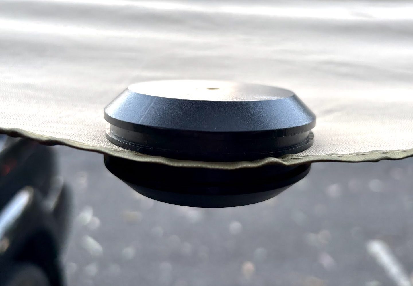 A magnetic hook stuck to the edge of the awning fabric, seen from the side