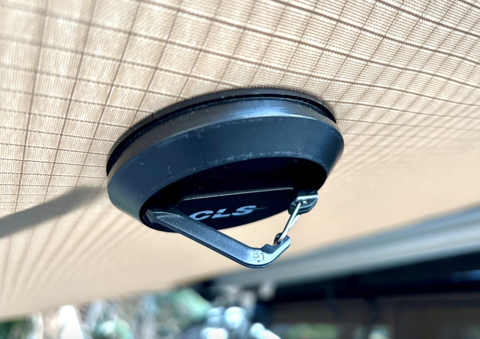 A magnetic camping hook stuck under the awning, seen from below