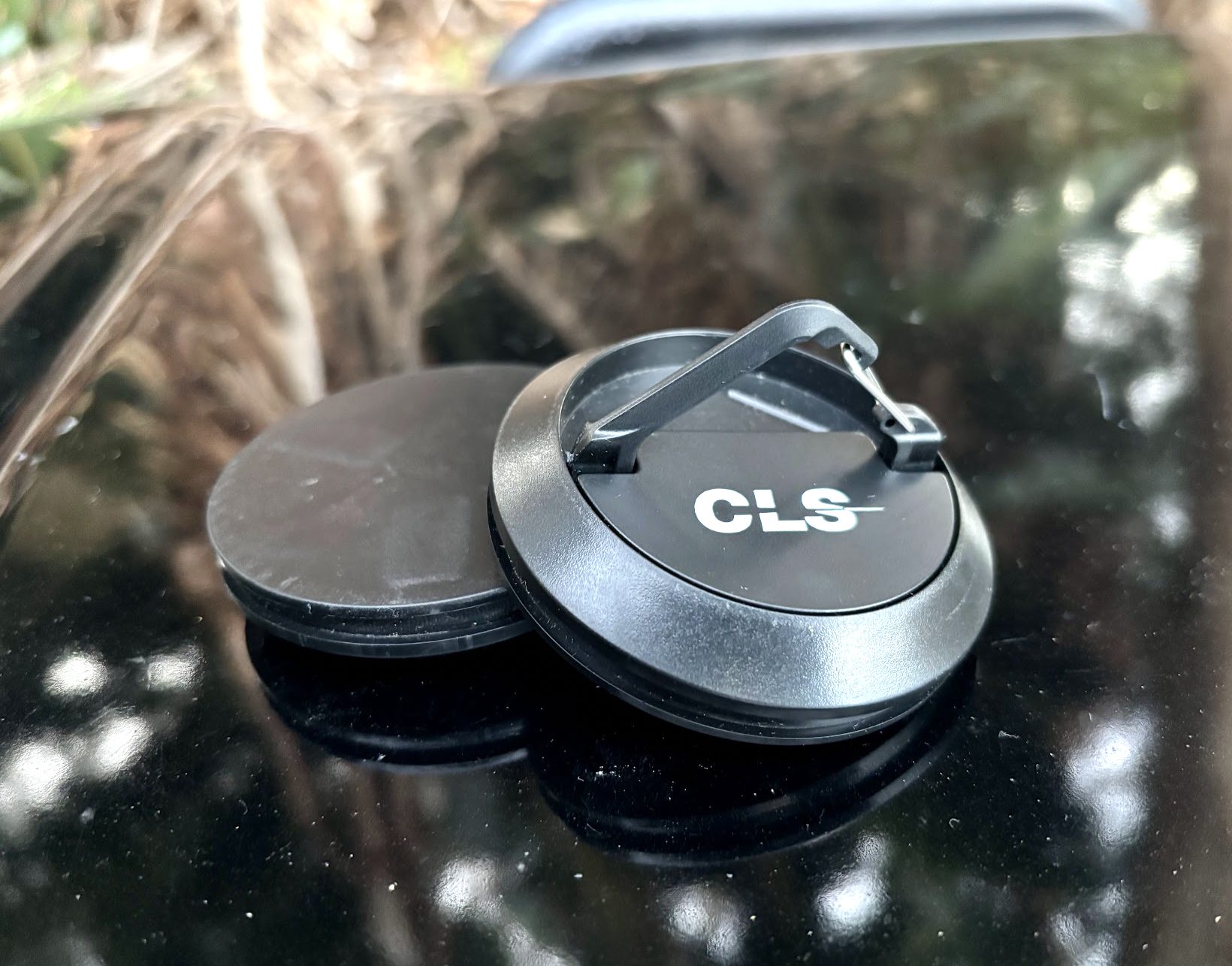 Two black magnetic camping hooks on the bonnet of the car, one with its carabiner up