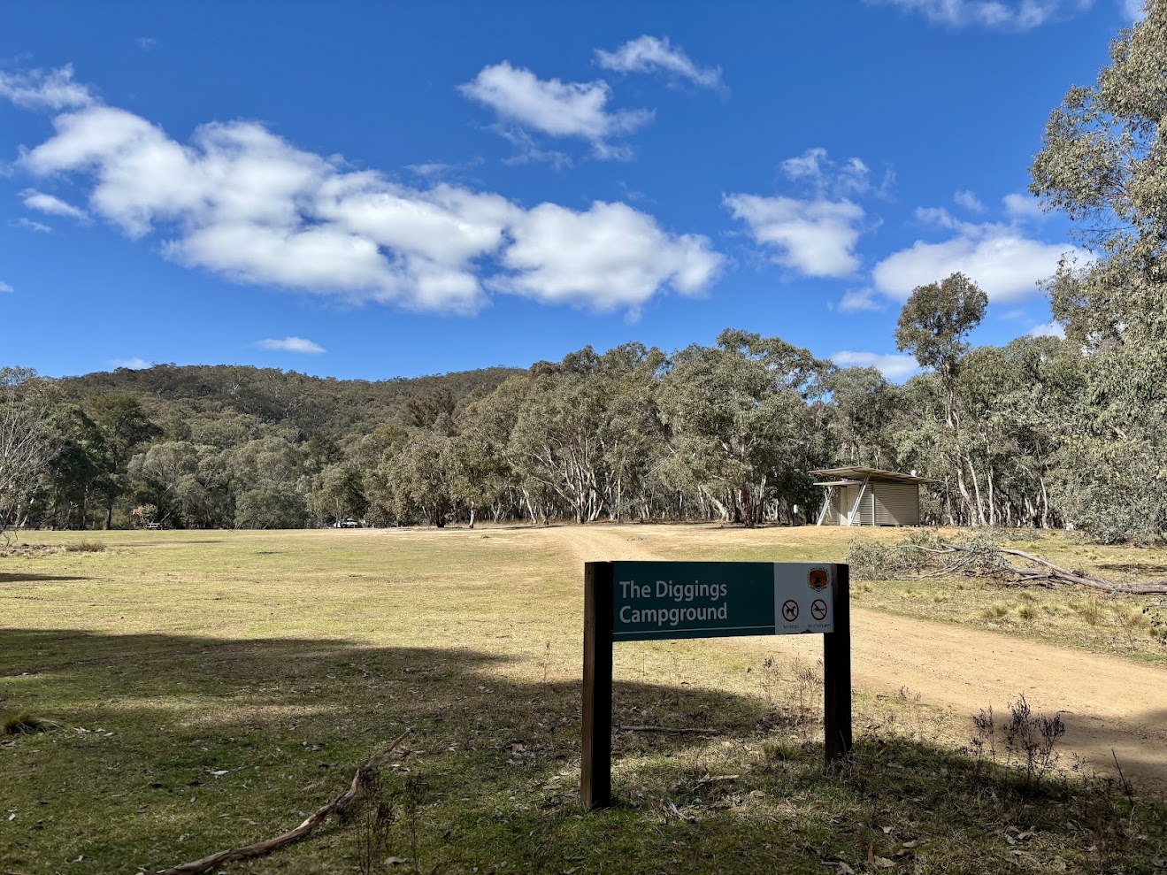 The Diggings Campground sign at the edge of the grass camping area
