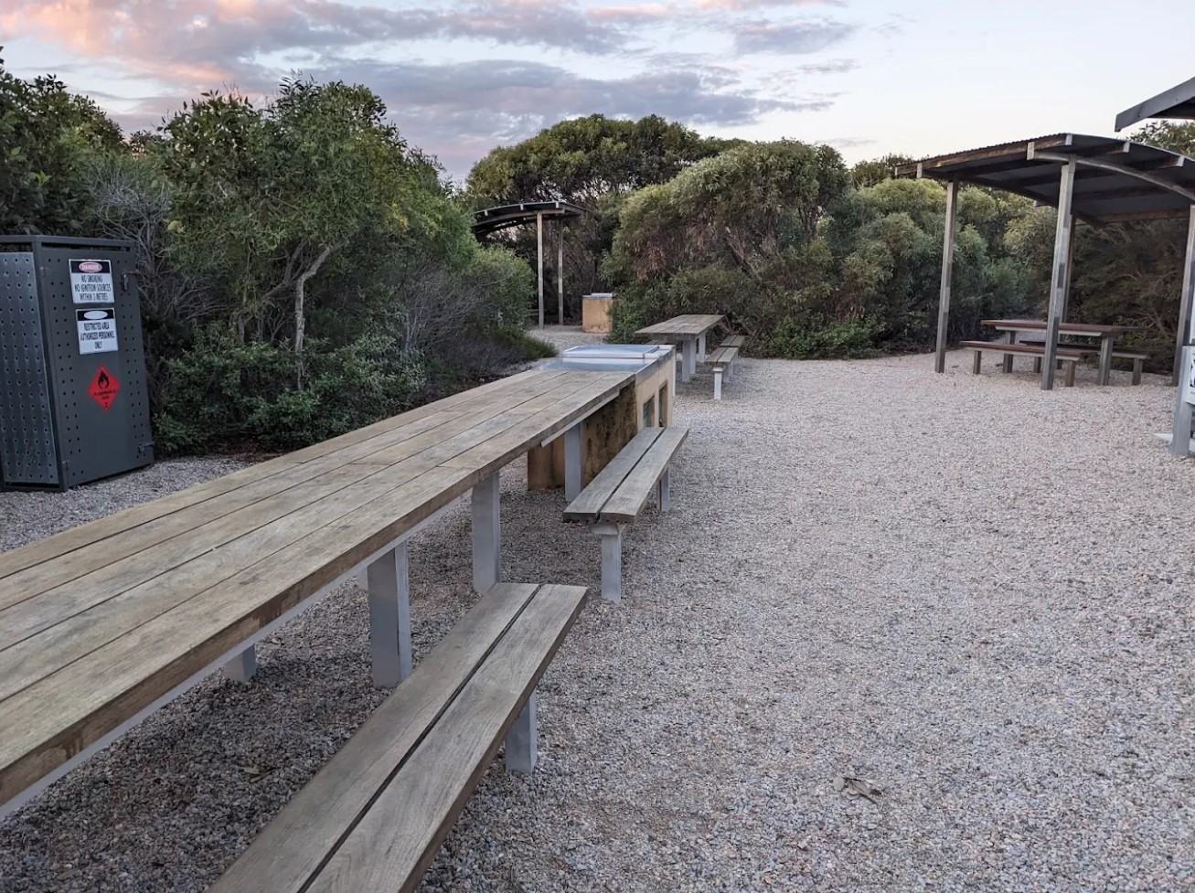 The common area with long picnic tables under shelters at Four Mile Campground