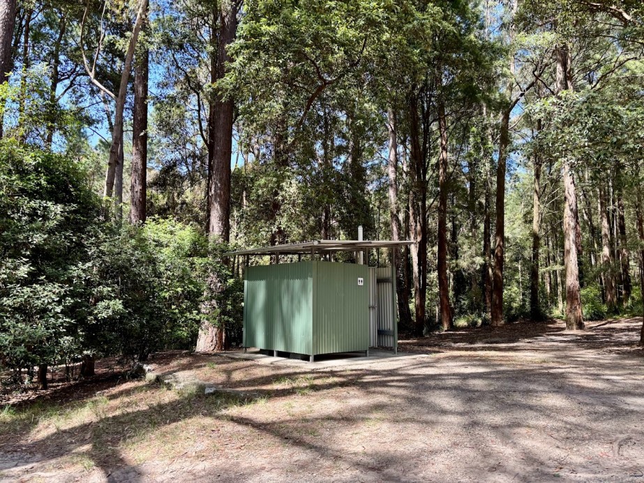 The green long-drop toilet at the east end of The Pines campground